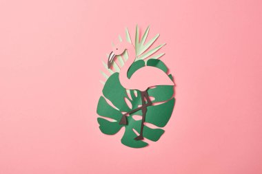 pembe arka plan üzerinde yeşil palmiye yaprakları üzerinde kağıt kesme flamingolar üst görünümü