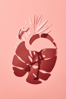 pembe arka plan üzerinde kağıt kesilmiş palmiye yaprakları ve flamingo üst görünümü