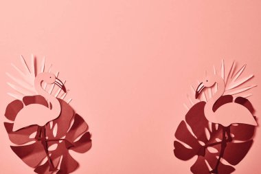 pembe arka plan üzerinde kağıt kesilmiş palmiye yaprakları ve flamingolar üst görünümü