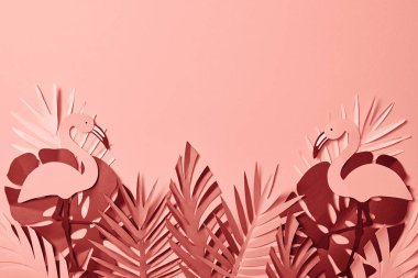 kağıt üst görünümü pembe arka plan üzerinde renkli palmiye yaprakları ve flamingolar kesilmiş