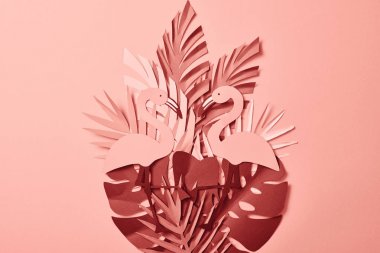 pembe arka plan üzerinde pembe egzotik kağıt kesim palmiye yaprakları ve flamingolar üst görünümü