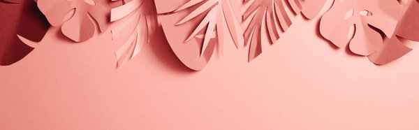 top view of paper cut exotic palm leaves on pink background, panoramic shot