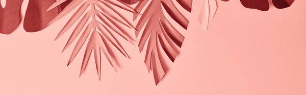 top view of colorful paper cut palm leaves on pink background, panoramic shot