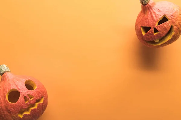 Widok Góry Rzeźbione Upiorny Dynie Halloween Pomarańczowym Tle Kopią Przestrzeni — Zdjęcie stockowe