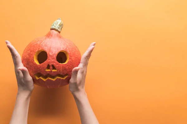 Turuncu Arka Plan Üzerinde Oyulmuş Ürkütücü Halloween Kabak Tutan Kadın — Stok fotoğraf