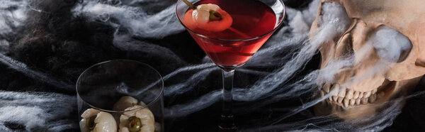 панорамный снимок жуткого человеческого черепа при красном освещении, украшение на Хэллоуин
