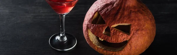 Plano Panorámico Calabaza Halloween Tallada Cóctel Rojo Sobre Fondo Negro — Foto de Stock