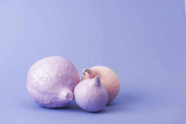 mor arka plan üzerinde pastel renkli boyalı kabaklar