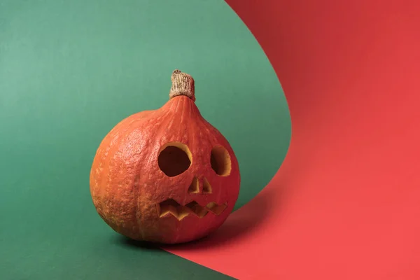Espeluznante Calabaza Halloween Tallada Sobre Fondo Rojo Verde — Foto de Stock