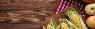 ahşap yüzeyüzerinde damalı masa örtüsü üzerinde elma yakın ham mısır ile kesme tahtası panoramik çekim