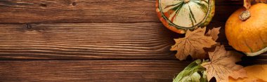 kuru yaprakları ile kahverengi ahşap yüzeyüzerinde ham kabak panoramik çekim