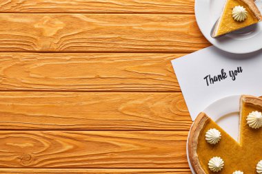 top view of pumpkin pie and thank you card on wooden table clipart