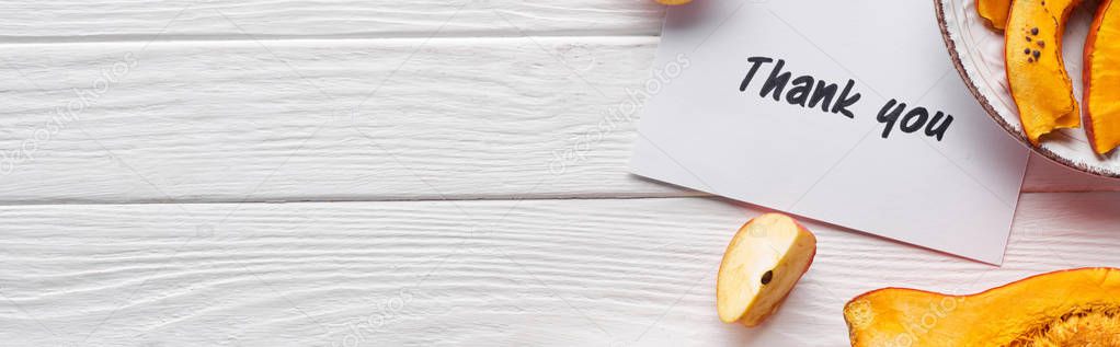 top view of pumpkin, ripe apples and thank you card on wooden white table, panoramic shot