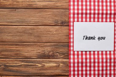 top view of thank you card on wooden brown table with red plaid napkin clipart