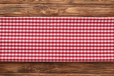 top view of red checkered napkin on wooden brown table clipart