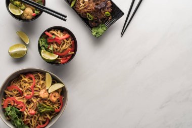 Lezzetli Tayland erişteleri ve mermer gri yüzey üzerinde yemek çubukları.