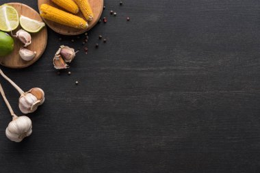 Tahta gri yüzeyde mısır, sarımsak, biber ve kireç manzarası