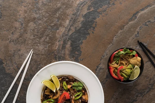 石の表面に箸が付いた新鮮な辛いタイ麺の上からの眺め — ストック写真