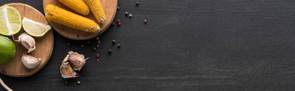 top view of corn, garlic, peppercorn and lime on wooden grey surface with copy space, panoramic shot