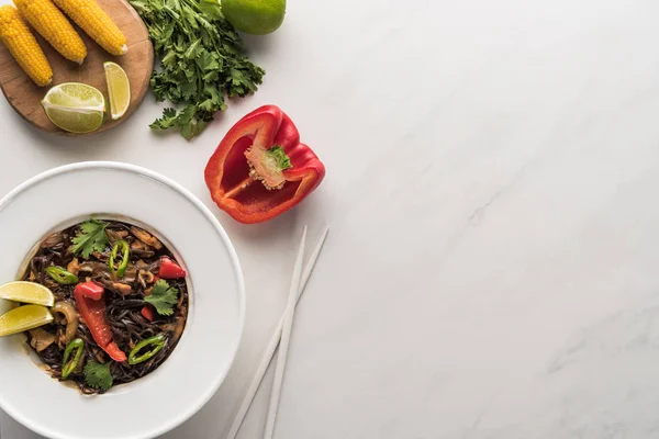 Top view of delicious spicy thai noodles near chopsticks, corn. bell pepper, and parsley on marble grey surface — Stock Image Top View Delicious Spicy Thai Noodles Chopsticks Corn Bell Pepper Stock Picture
