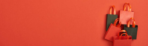 верхний вид торговых мешков на красном фоне с копировальным пространством, панорамный снимок
