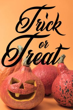 Turuncu arka planda Cadılar Bayramı balkabağı oyulmuş, şaka mı şeker mi illüstrasyonuyla.