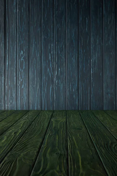 Mesa de madera verde y pared de madera azul oscuro - foto de stock