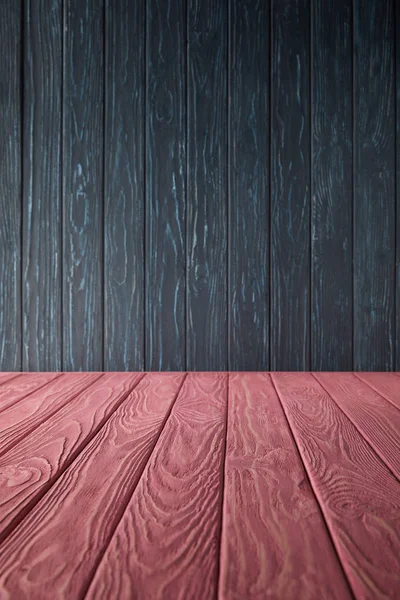 Pink wooden table and dark blue wooden wall — Stock Photo