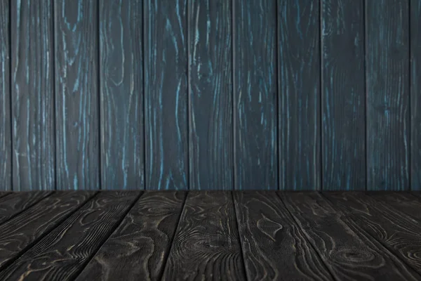 Темно-серый деревянный стол и темно-синяя деревянная стена — стоковое фото