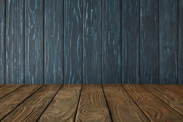 Brown striped tabletop and dark blue wooden wall — Stock Photo