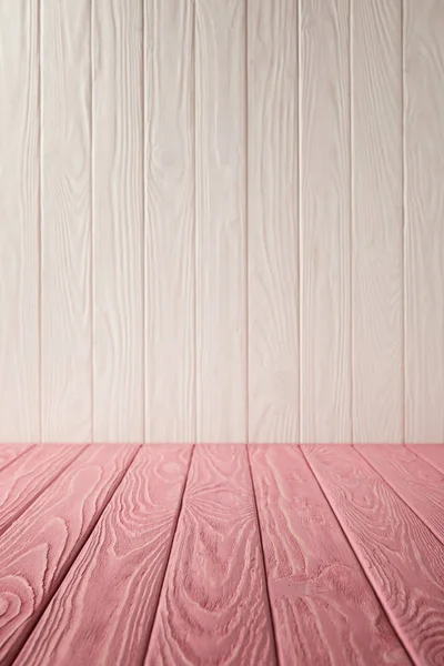 Pink striped tabletop and white wooden wall — Stock Photo