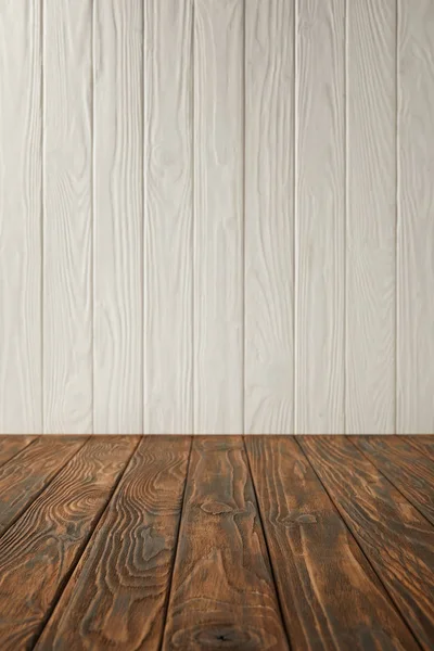 Mesa a rayas marrón oscuro y pared de madera blanca - foto de stock