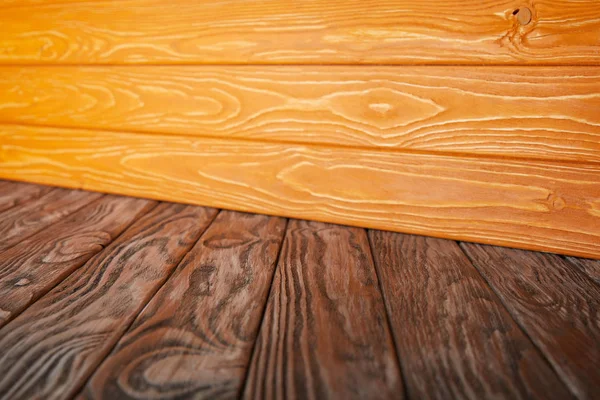 Pavimento a strisce di legno marrone e parete di legno arancione — Foto stock