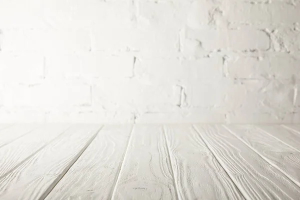 White wooden tabletop and white wall with bricks — Stock Photo