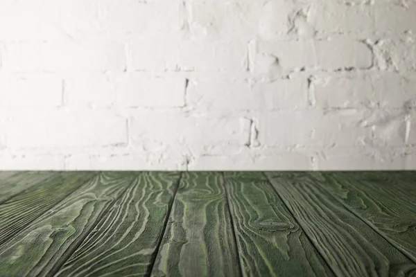 Mesa de madeira verde escuro e parede branca com tijolos — Fotografia de Stock
