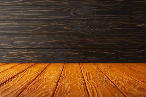 Mesa a rayas naranja y pared de madera oscura - foto de stock