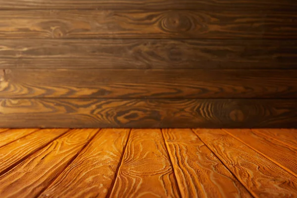 Mesa a rayas naranja y pared de madera marrón - foto de stock