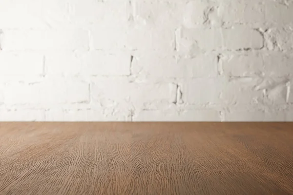 Brown wooden tabletop and white wall with bricks — Stock Photo