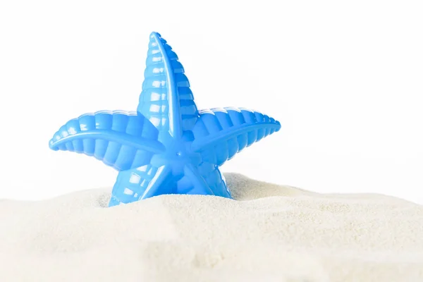 Toy starfish in sand isolated on white — Stock Photo