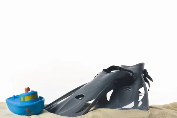 Flossen und Spielzeugboot im Sand isoliert auf weiß — Stockfoto