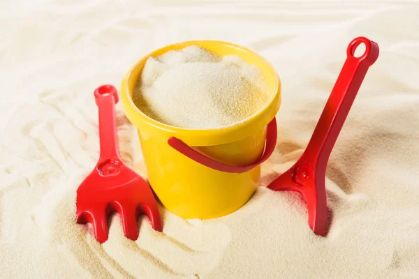 Seau et jouets en plastique sur la plage de sable — Photo de stock