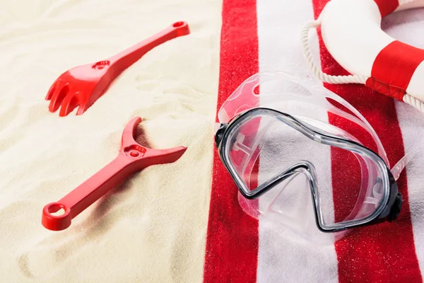 Masque de plongée et jouets sur la plage de sable — Photo de stock