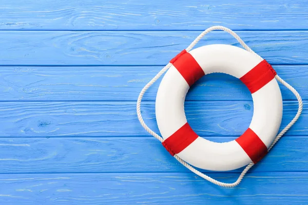 White and red life ring on blue wooden background — Stock Photo