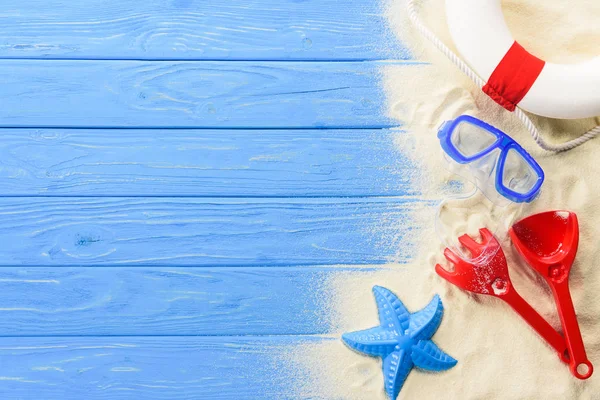 Maschera subacquea e giocattoli da spiaggia su sfondo blu in legno — Foto stock