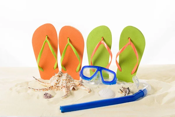 Flip flops and diving mask in sand isolated on white — Stock Photo