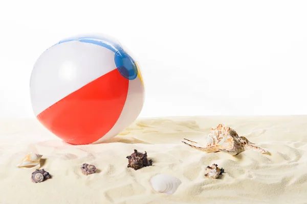 Pelota de playa con conchas marinas en arena aislada sobre blanco - foto de stock