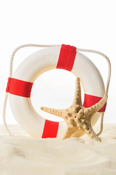 Life ring and starfish in sand isolated on white — Stock Photo