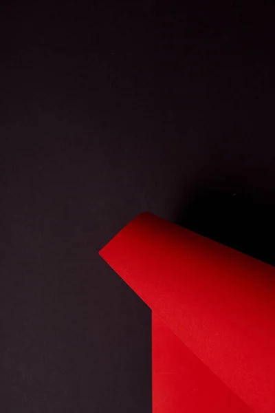 Feuille de papier rouge frisée sur fond noir — Photo de stock
