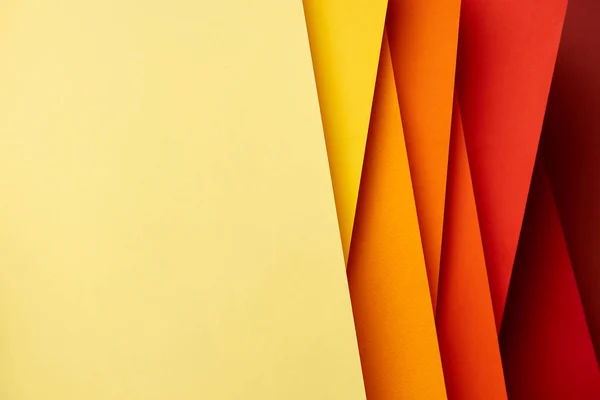 Patrón de hojas de papel superpuestas en tonos rojos y amarillos - foto de stock
