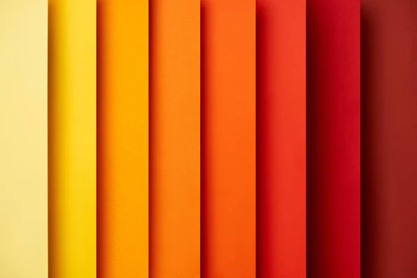 Fondo abstracto con hojas de papel verticales en tonos rojos y amarillos - foto de stock